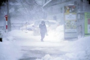 12月23日，行人在日本山形縣山形市藏王溫泉冒雪前行。（圖：新華社）
