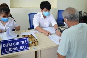 一名退休幹部在當地保險機關簽領退休金。（圖：人民報）