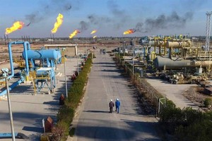 石油工人走在巴士拉以北的Nihran Bin Omar油田内的一条小路上。（图：INA）