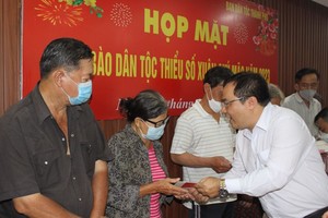 市民族处民族政策科科长陈志伟向华人贫困户赠送新年礼物。