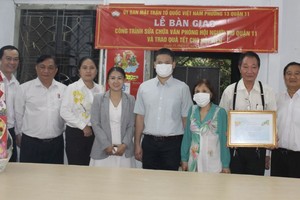 郡、坊领导与茶山庆云南院住持周华邦(右二)向盲人会移交修漏工程。