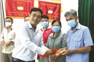 文忠孝编委向平政县华人赠送利是。