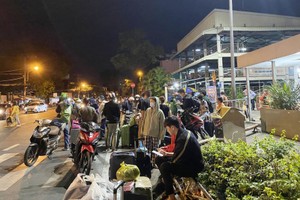 大年初五凌晨时段，乘客搂着其行李在东区车站大门呆着等待搭摩的与计程车回家。 （图：N.A）