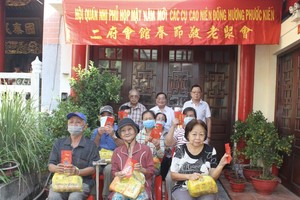 二府会馆理事长彭伟强、副理事长谢忠成、彭志光（后排）向诸位高龄乡亲赠送春节敬老礼物。