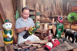 阮文圆时不时将木偶拿出来清理修复。