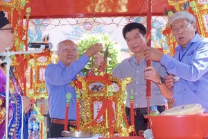 守德市七府关帝庙代表向江杰华（右二）移交“合家平安”圣灯。