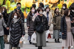 当地时间2023年1月27日，日本东京，人们戴着口罩等待过马路。（图：视觉中国）