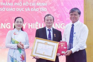 市人民议会主席阮氏丽向范玉茂同志颁授50年党龄纪念章。（图：市党部新闻网）