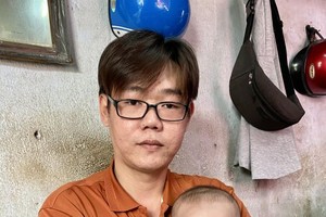 陈志满抱着正待施手术的儿子陈镇凯。