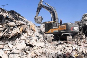 图为2月14日，救援人员操作机械在土耳其哈塔伊省安塔基亚市开展地震救援工作。（图：新华社）