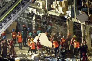 救援人员搬运遇难者遗体。（图：新华社）