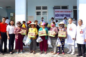 第五郡东医会领导（右一右二）与地方领导向病人发送药品与方便面。