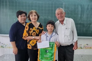 颍川双语学校副校长范氏绒(左二)代表董事会颁发奖金给千怡小妹妹。