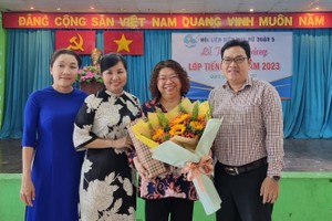 第五郡妇联会主席陈氏雪幸向市各民族文学艺术协会常值副主席张四妹赠送鲜花。