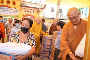 龙华寺住持释慧功和尚、澳洲悉尼市般若寺般若法师向贫困户赠送礼物。