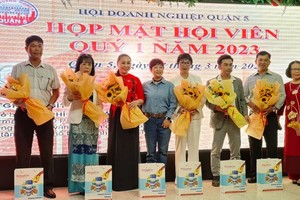 第五郡商会主席苏慧兰（左四）向新会员送花送贺。