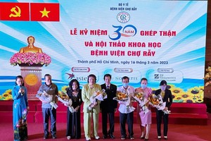 市大水镬医院院长阮知识（中）向器官移植成功者赠送鲜花。