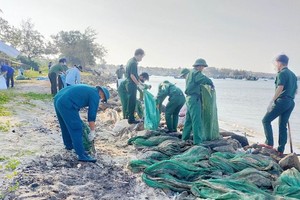 青年突击队员们正在收集海滩上的塑料垃圾。（图：人民军队报）