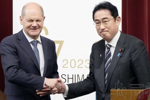 3月18日晚，日本首相岸田文雄（右）和德国总理朔尔茨在首相官邸举行联合记者会后握手。（图：共同社）