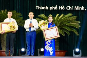 市委书记阮文年（中）向市人民议会主席阮氏丽、市委宣教处副主任范德海颁授三等劳动勋章。（图：黄雄）