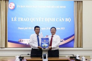 市人委会副主席杨英德（右）向武明成同志颁授人事委任《决定》。（图：VGP）