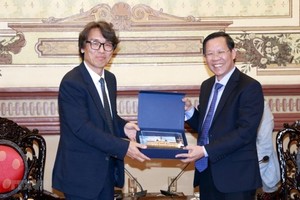 市人委会主席潘文迈（右）向韩国环境部副部长金恒升赠送纪念品。（图：越通社）