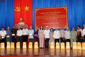 国家副主席武氏映春（中）向平阳省滨桔市优抚政策对象赠送礼物后合影留念。（图：人民报）