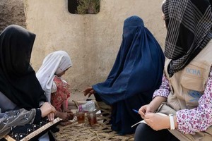 在阿富汗东部的楠格哈尔省，人道协调厅的一名工作人员与流离失所的妇女交谈。（图：联合国）