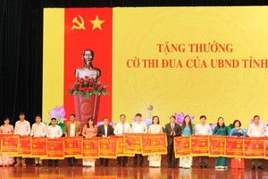 高平省人委会主席黄春映向先进模范颁赠出色竞赛锦旗。（图：高平报）