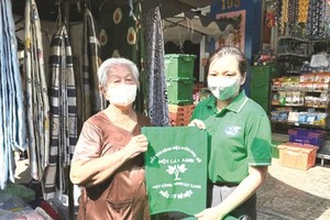 各坊妇联会向居民、街市商贩赠送环保袋。