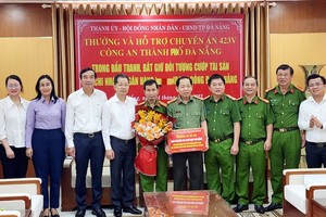 岘港市领导向侦破打劫银行案件的公安力量表彰并合影。（图：人民公安报）