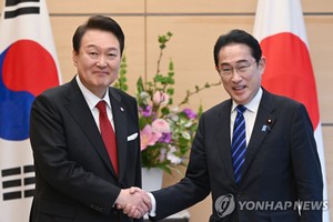 3月16日下午，在位于东京的日本首相官邸，韩国总统尹锡悦（左）同日本首相岸田文雄在举行小范围会谈前握手合影。（图：韩联社）