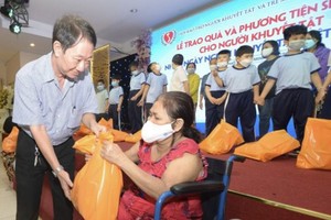 第十一郡茶山庆云南院住持周华邦代表赞助单位向残疾人士赠送礼物。