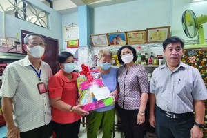 第五郡郡委书记黄玉女芳红(右二)看望华人革命有功者何金惠大娘。