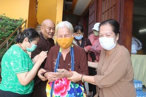 释镇静和尚与蔡婉霞居士正派发礼物。
