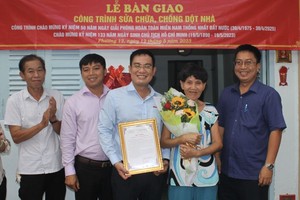 华文《西贡解放日报》编委文忠孝（中）和郡、坊领导祝贺卢月好大娘（右二）。