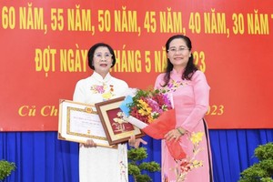 市人民议会主席阮氏丽（右）向市委原副书记阮氏秋霞授予45年党龄纪念章。（图：市党部新闻网）