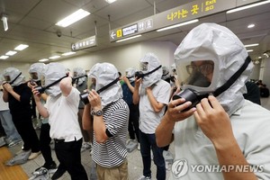 图为 2022年8月24日，在仁川市富平区政厅站，民防队员演练佩戴防毒面具。（图：韩联社）