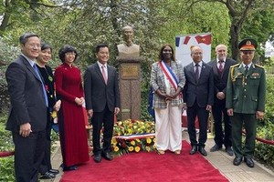 与会代表在胡志明主席像前合影。（图：越通社）