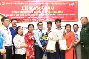 本报编委文忠孝（左五）与第十一郡、坊领导、代表出席移交温情屋仪式。