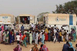 乍得的苏丹难民接受世界粮食计划署的粮食援助。（图：联合国）