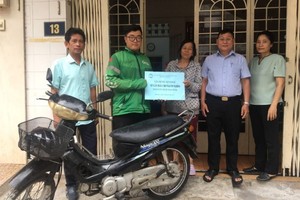 第十一郡第八坊越南祖国阵线委员会代表和热心人士阮氏舒庄向青年赠送谋生工具。