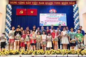 市劳动联团与新平郡领导为当地少儿派发礼物并合影。（图：市党部新闻网）