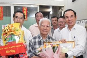 市委书记阮文年向寓居第十郡第九坊的吴光老人赠送礼物。（图：越勇）