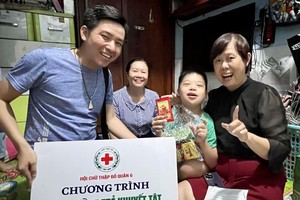 由红十字会主席黎氏宝庄（右）与代表团给俊英弟弟赠送礼物，他十分高兴。