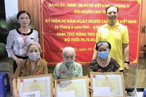 第十一郡高龄人会主任朱杞文（右一）和坊祖国阵线委员会主席范杭降秋（左一）向越华老人贺寿。