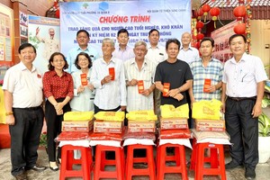 第十六坊代表和崇正慈善会理监事向贫困老人赠送礼物。