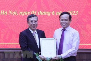 新任农业与农村发展部副部长黄忠（左）从政府副总理陈留光手中接过人事委任《决定》。（图：越通社）