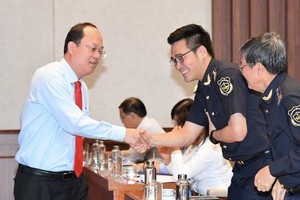 市委副书记阮胡海（左）同与会代表握手致意。（图：越勇）