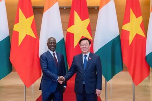 国会主席王廷惠（右）与科特迪瓦共和国国民议会议长阿达马‧比克多戈握手合影。（图：俊明）